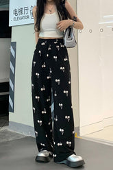 Lange schwarze Hose mit Kirschmuster und hoher Taille